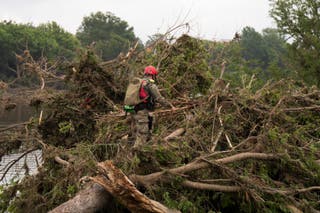 A U.S. Border Patrol officer searches through debris after massive flooding along the Guadalupe River on July 6